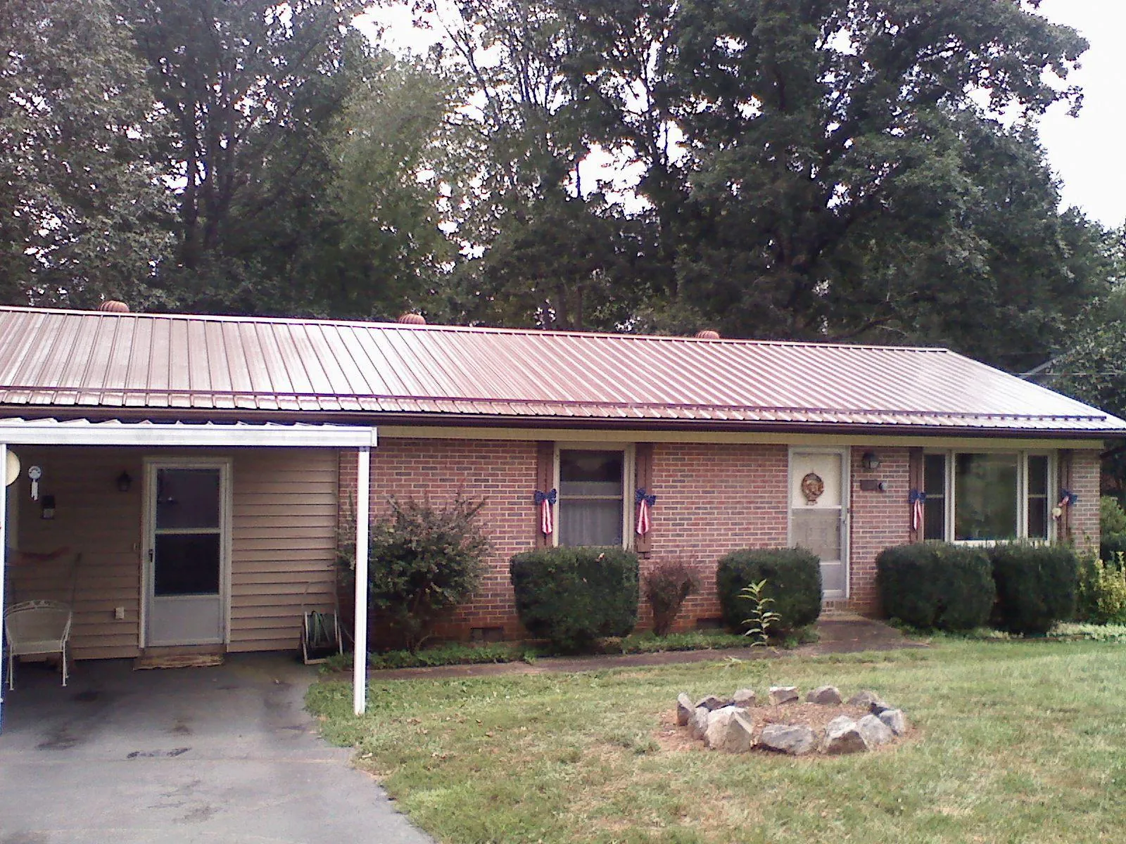 Bronze metal roof and carport on a brick ranch home — Roof Repair work by our crew in Chilton